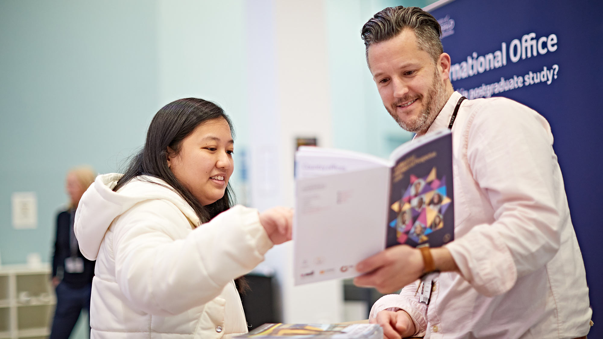 A student meets one of our team members at an information fair on campus.