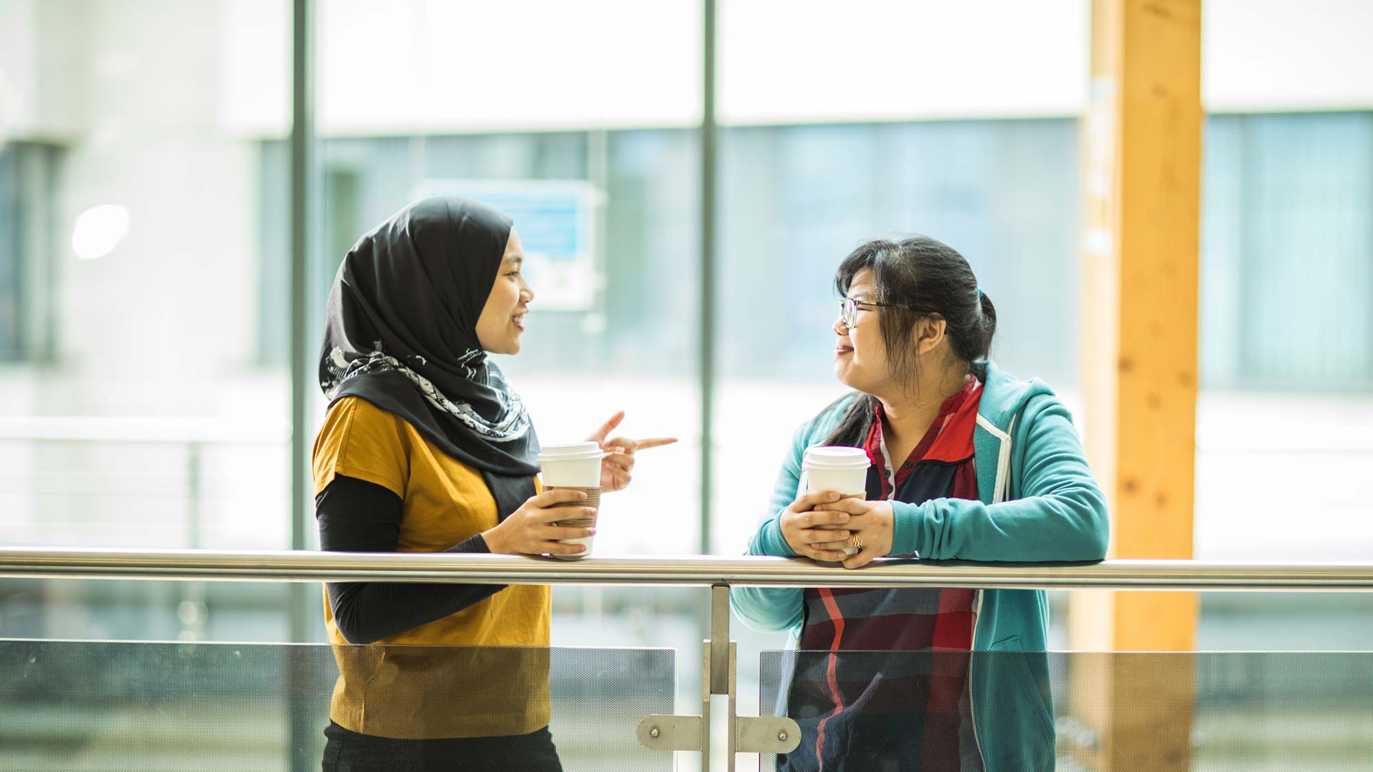 Students stand and talk to each other in the Oastler Building.