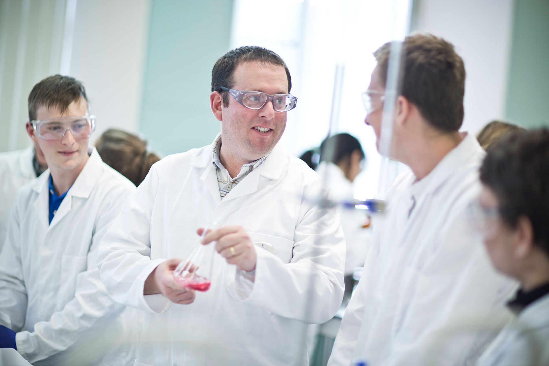 Lecturer talking to students in a lab