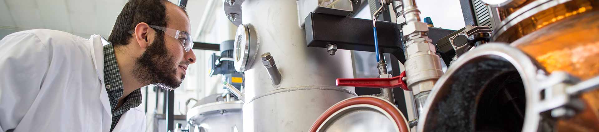 Student observing a piece of apparatus in the chemical engineering lab