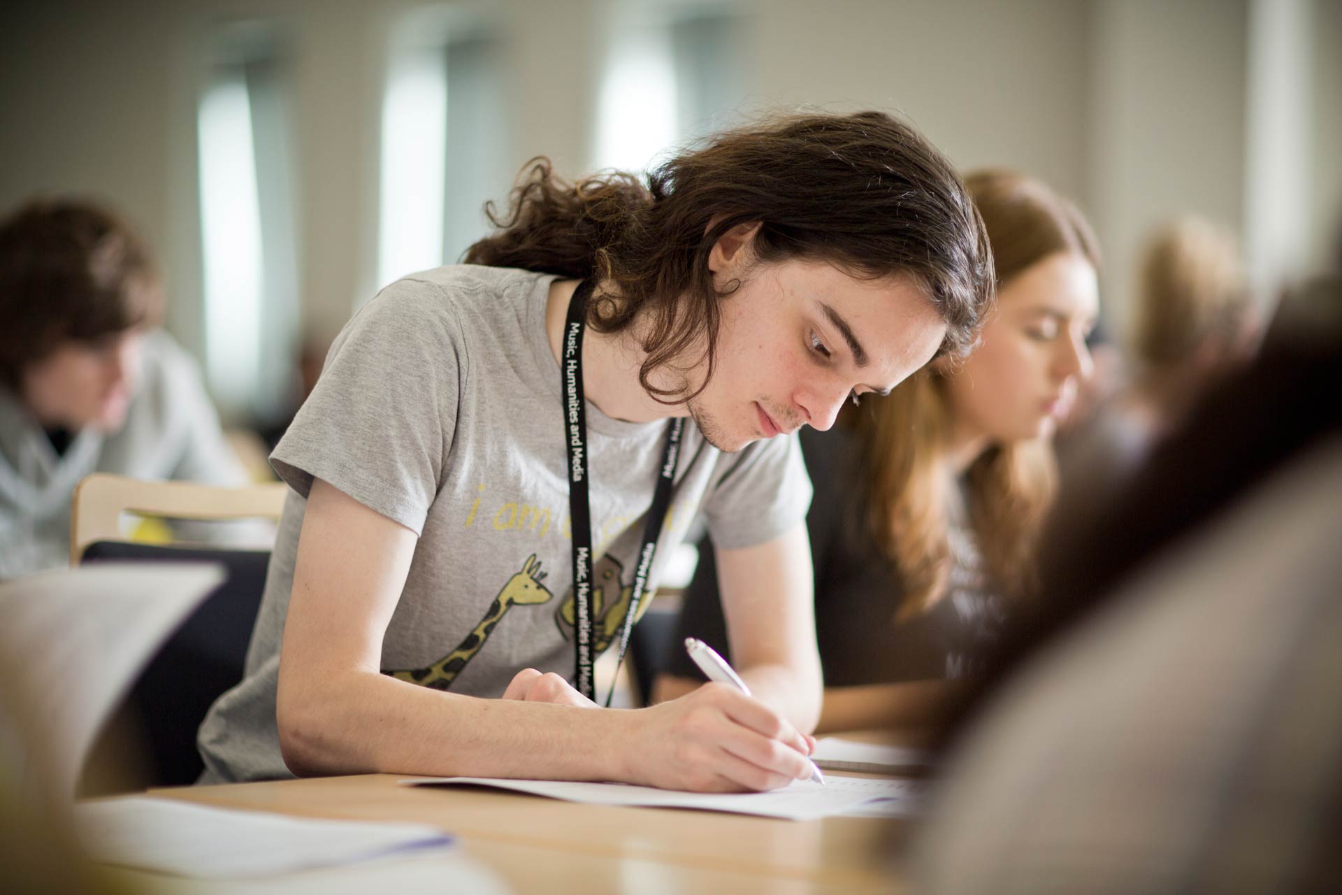 Student studying in class and writing